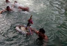 Mitropolit Hrizostom uručuje nagradu pobjedniku plivanja za Časni krst Plivanje za Časni krst